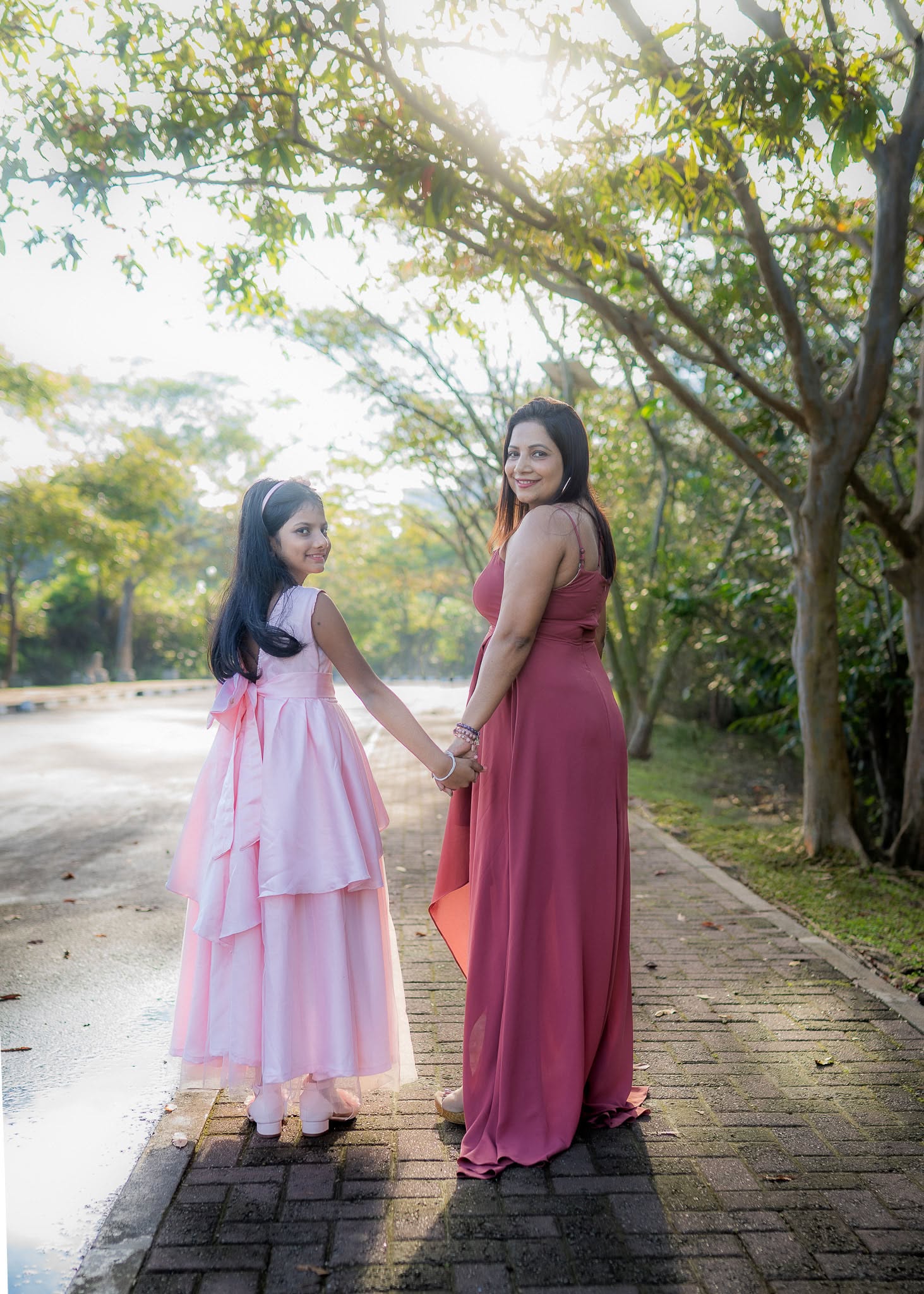 Mother and daughter birthday photoshoot walking hand in hand on a tree-lined path, Colombo, Sri Lanka